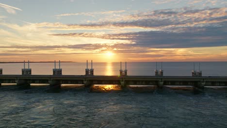 Drone-moving-up-behind-the-Oosterschelde-storm-surge-barrier-during-a-warm-summer-evening