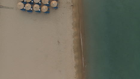 Flying-over-the-beach-with-chaise-longues-and-sun-umbrellas