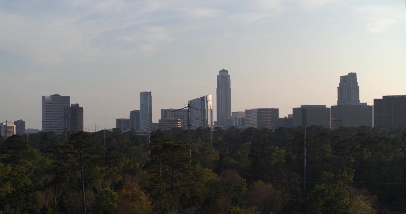 Vista aérea de drone do Distrito Uptown Galleria de Houston durante o pôr do sol, exibindo comércio de luxo, torres de escritórios, hotéis e desenvolvimento urbano moderno sob a luz quente da hora dourada.
