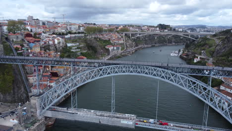 overhead shot of dom luís i bridge with pedestrians on the elevated walkway, aerial tilt down