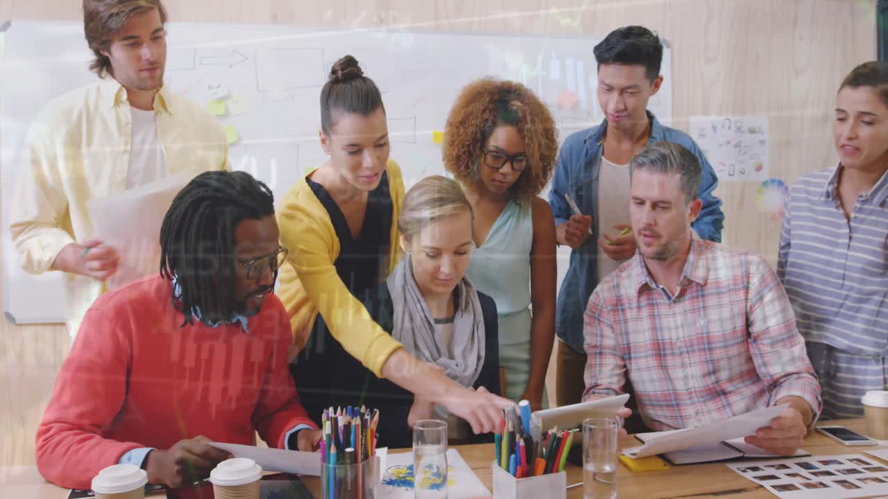 A group of executives are meeting in a conference room to discuss financial data and graphs