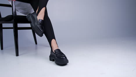 Woman wearing black platform loafers and leggings