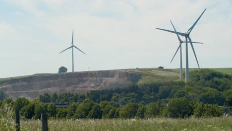 wind turbines rotating slowly on a rural wind farm in matlock, derbyshire, uk