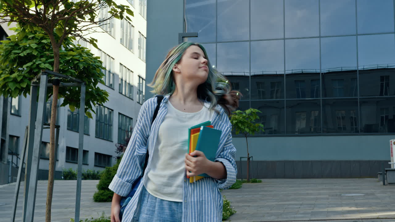 una adolescente caminando con libros en la escuela