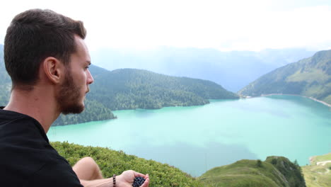 young man during a hike eats blueberries for a short break