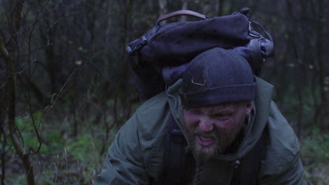 annoying man with mud in face standing up after fall down in wet muddy forest