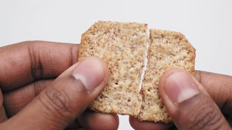 person holding a whole grain cracker