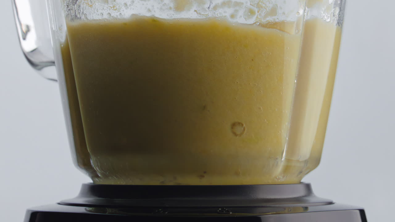 batido de frutas con vitaminas mezclado dentro del cuenco de la licuadora en cámara súper lenta de cerca