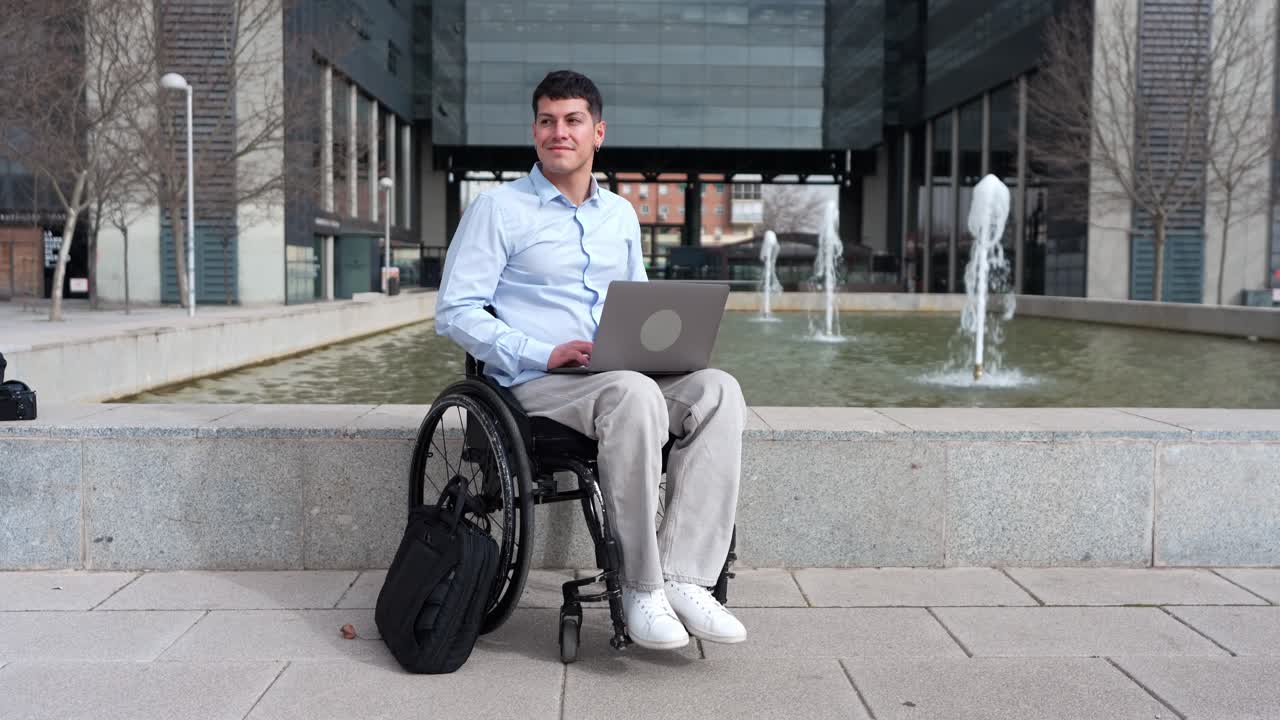 Jovem em cadeira de rodas trabalhando no laptop ao ar livre