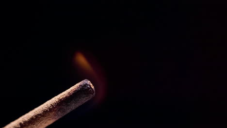 aromaterapia, palo de incienso quemado fuma sobre un fondo negro, primer plano