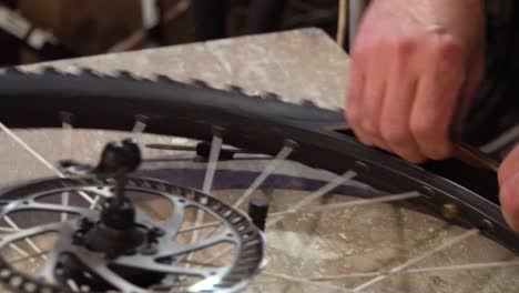 male hands repairing a bicycle wheel