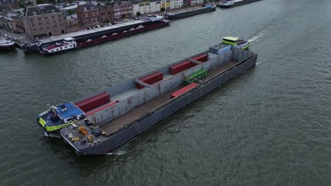barcaza de contenedores y catamarán navegando el uno al lado del otro