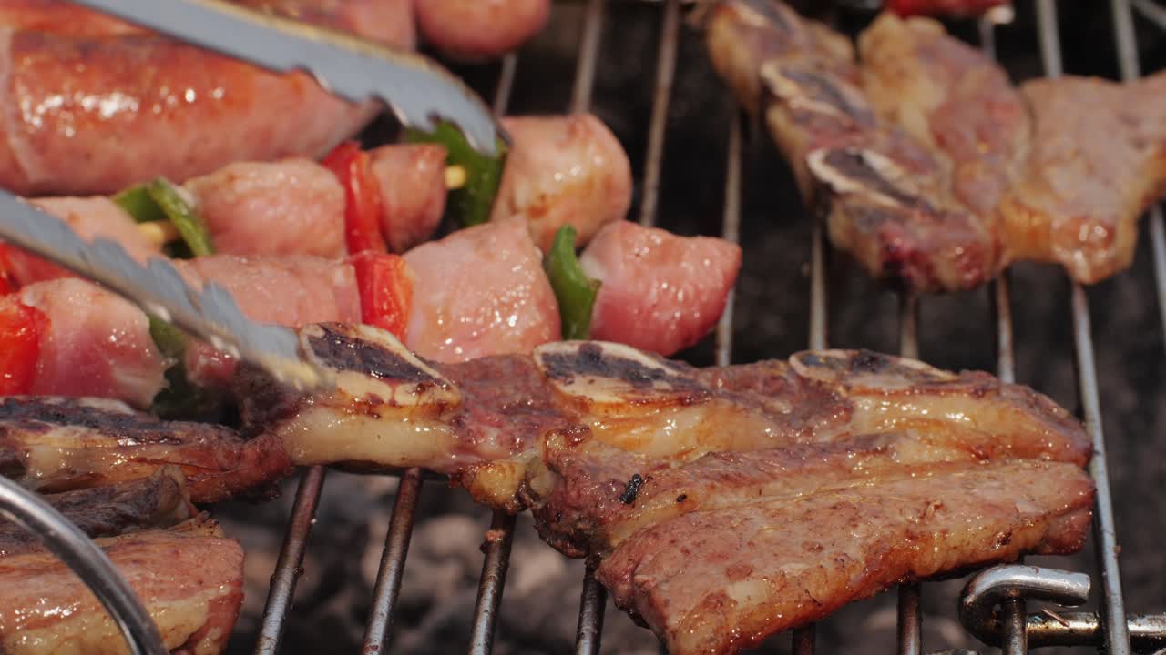 Traditional spanish barbeque, big sausage chorizo botifarra, pork and beef ribs on grill with fire, american style cooking, chef grilling meat fat food, steaks and sausages on bbq. High quality 4k footage
