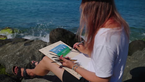 woman painting a seascape on the beach