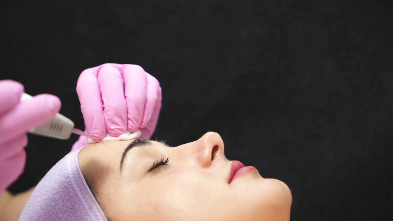 Beautiful woman in a beauty salon. Professional procedure of ultrasonic face cleansing. Cosmetologist job. Aesthetic cosmetology.