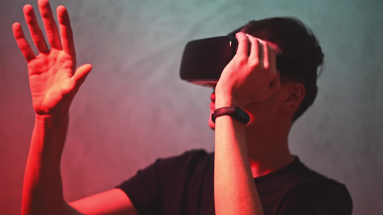A boy who gestures in a virtual reality with a red and blue backround
