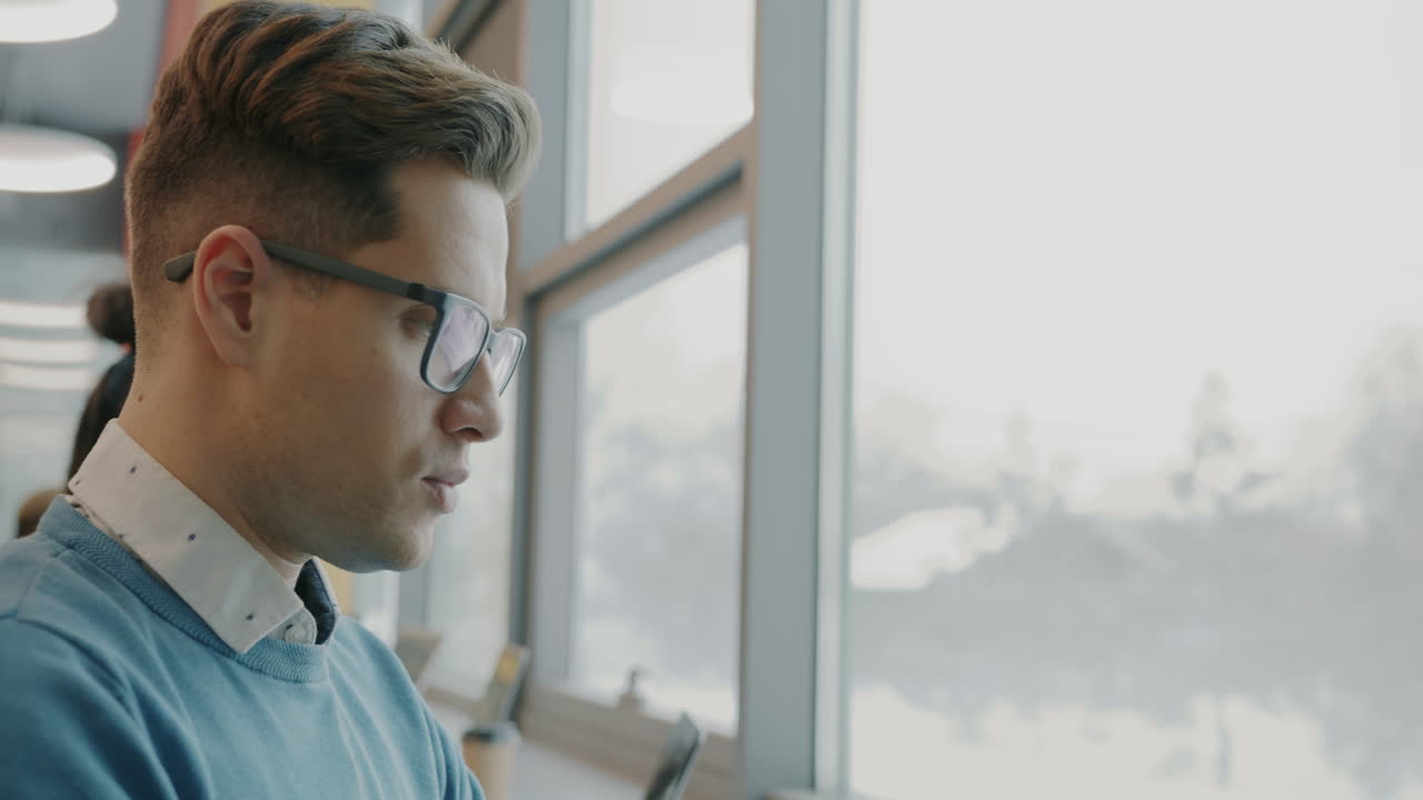 Man working on a laptop in a modern office setting