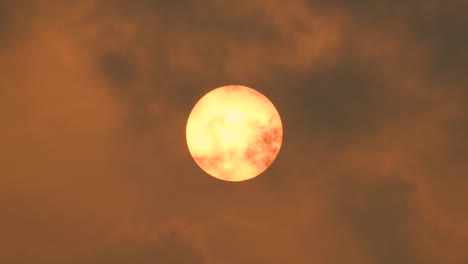 Close-up-shot-of-sun-covered-by-dark-polluted-smoke-clouds,-orange-misty-sky