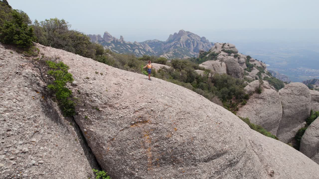 mujer haciendo ejercicio en la cima de la montaña, montserrat barcelona