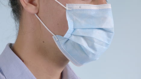 close-up portrait of a man wearing a safety surgical face mask