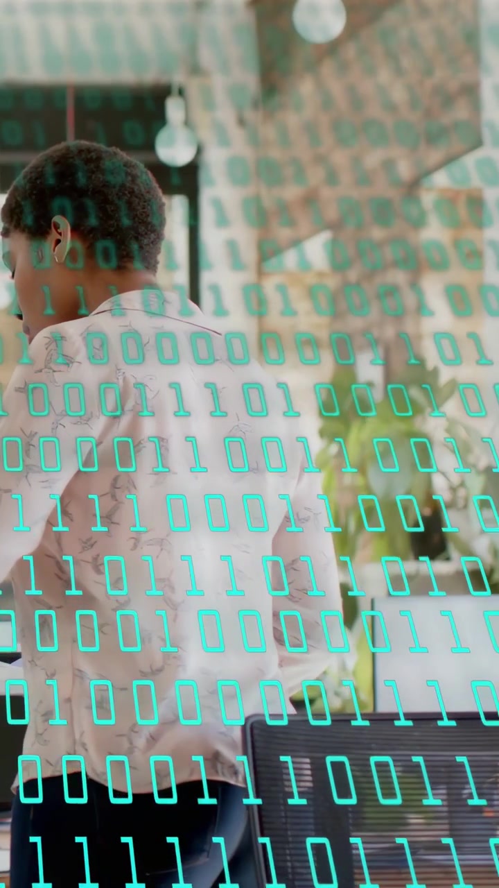 Vertical video: Worker shifting, turning and stepping to desk to check screen tech overlaying scene