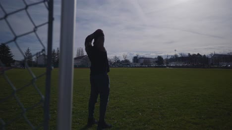 Male-Wearing-Headphones-and-Stretching-Arms-Above-Head---Strong-Athletic-Muscular-Black-Man-Fitness-Outdoor-Training-Preparation-In-4K