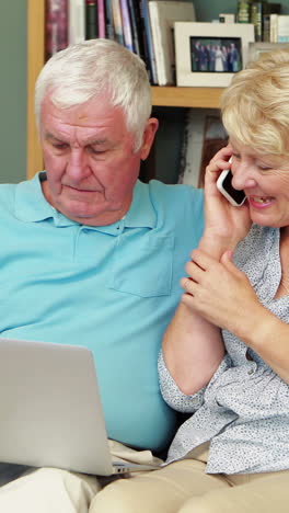 pareja de ancianos usando portátil y teléfono inteligente