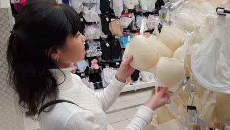 woman shopping in mall. choosing underwear, bra.