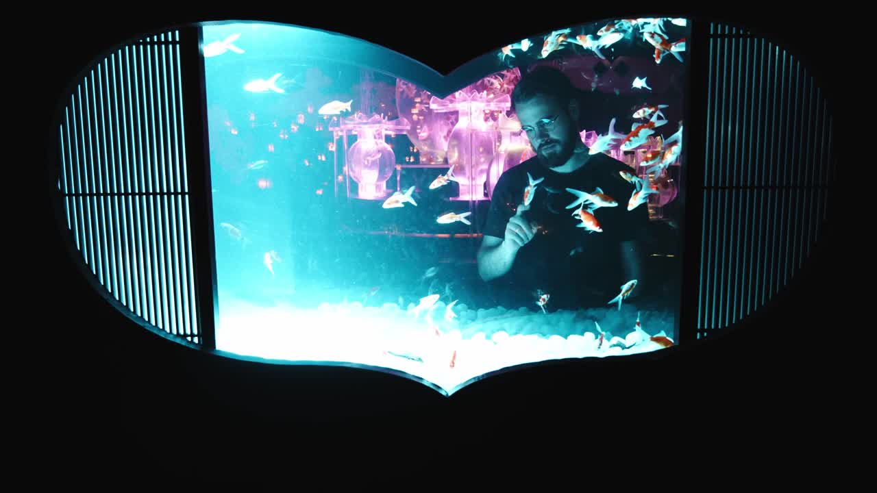 4k cinematic footage of a guy looking across an aquarium with a heart shape in Tokyo