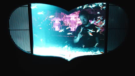 4k cinematic footage of a guy looking across an aquarium with a heart shape in tokyo