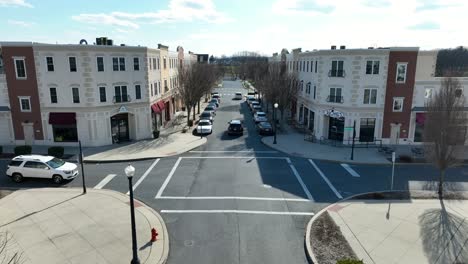 Aerial-dolly-above-shops-at-four-way-intersection-in-calm-suburban-town