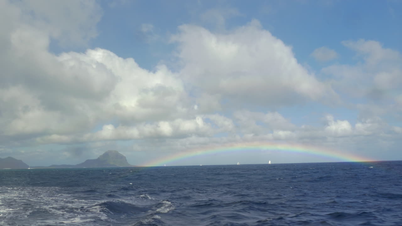 vista del arco iris contra el cielo azul con nubes en el océano índico isla de mauricio