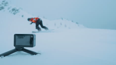 smal action cam capturing a snowboarder.