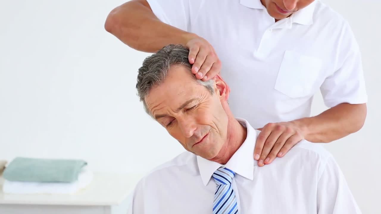 fisioterapeuta dando a un hombre de negocios un masaje de cuello