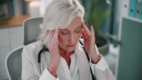 senior doctor in office with headache