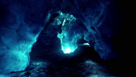 blue ice cave covered with snow and flooded with light