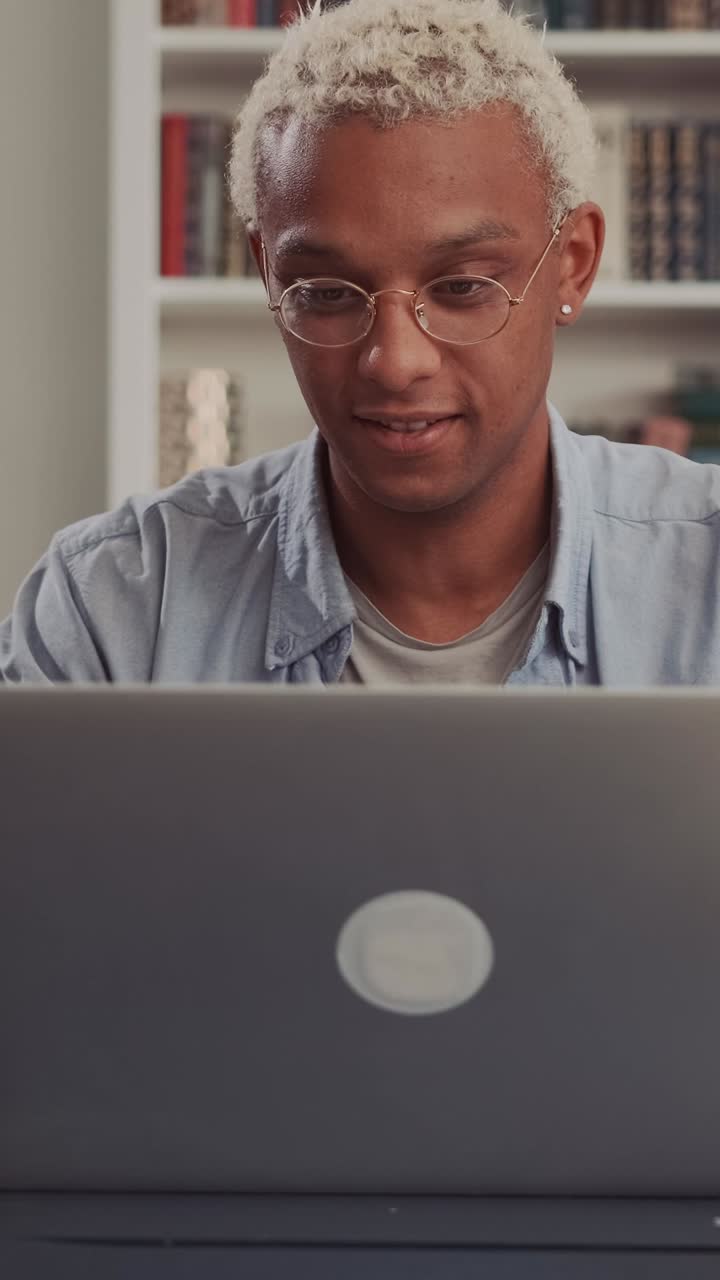 Young african american man freelancer opens laptop and starts doing work