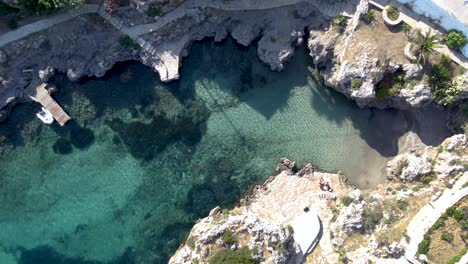 aerial top view avlemonas bay swiming area with crystal clear waters and couple, kythira island, greece