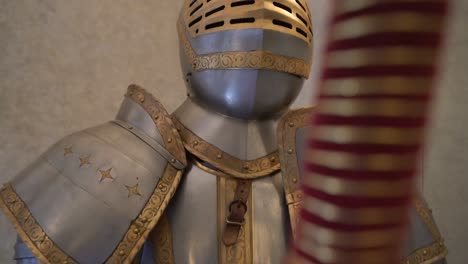 close up historic ancient metal suit of armour on display in museum