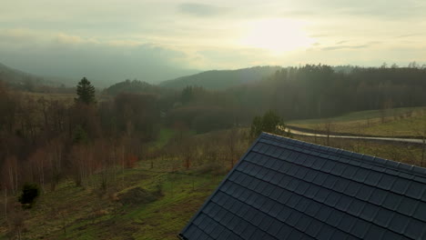 Eine-Hütte-überblickt-Eine-üppige,-Mit-Jungen-Bäumen-Säumen-Einen-Absteigenden-Weg-In-Eine-Ruhige,-Bewaldete-Landschaft-Unter-Einem-Weichen,-Leuchtenden-Himmel