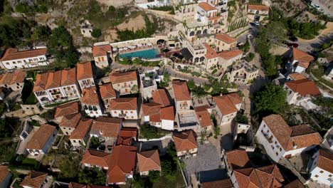 Beautiful-village-on-coastline-of-Ionian-sea-in-Albania-with-resorts,-stone-houses,-cobblestones-on-narrow-alleys-and-church