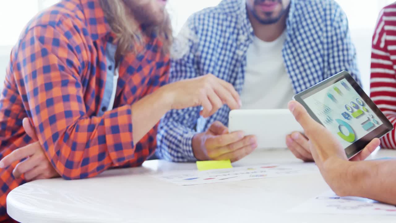 colegas discutiendo sobre una tableta digital en la mesa 4k