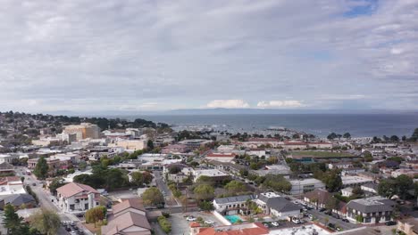 Toma-Aérea-Baja-Y-Amplia-Del-Antiguo-Muelle-De-Pescadores-En-La-Bahía-De-Monterey-Desde-El-Centro-De-Monterey,-California