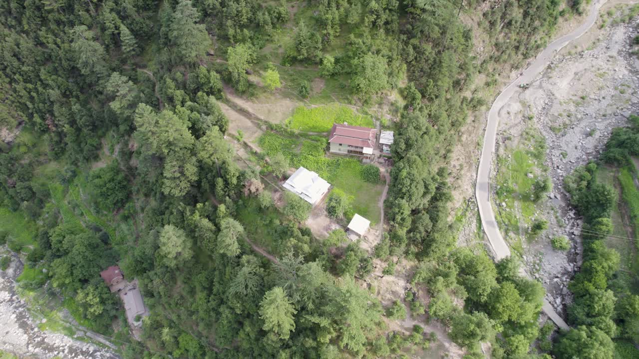 울창한 초록색 언덕과 아래로 흐르는 휘어지는 강으로 둘러싸인 어져 있는 집들