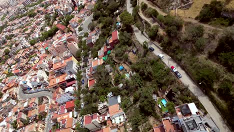 cinematic action aerial drone shot of barcelona cityscape with street view and vehicles running on the road and communication tower