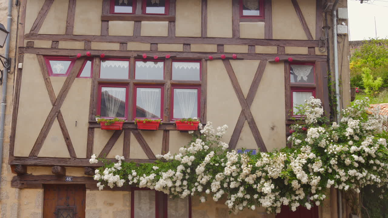 Charming medieval house with timber framing and flower boxes in Parthenay, France, summer day