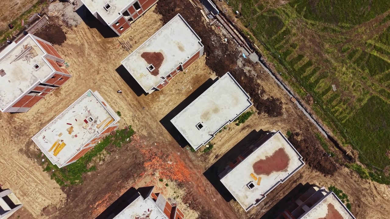 Cantiere edile con diversi edifici incompiuti situato in un'area urbana in fase di sviluppo durante le ore diurne.