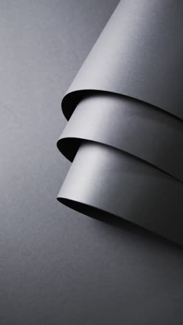 vertical video of close up of rolls of black paper and copy space on black background