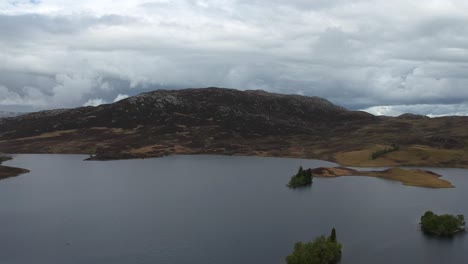 Tilt-down-droneshot-of-scottish-higland-lake-island