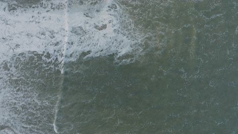 tomada aérea de arriba hacia abajo de drones de la marea alta en la playa de pismo, california, al amanecer